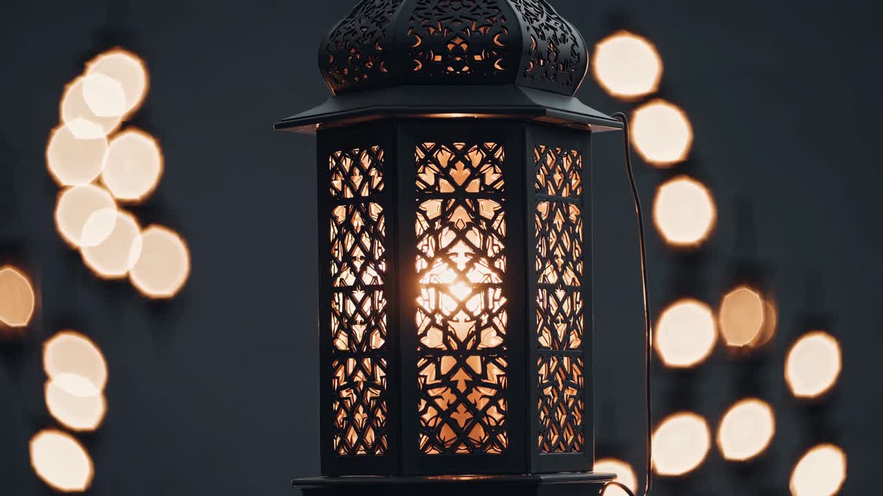 Intricately designed lantern glows warmly against a dark backdrop, its light creating a soft, circular bokeh effect, evoking a sense of tranquility and peace