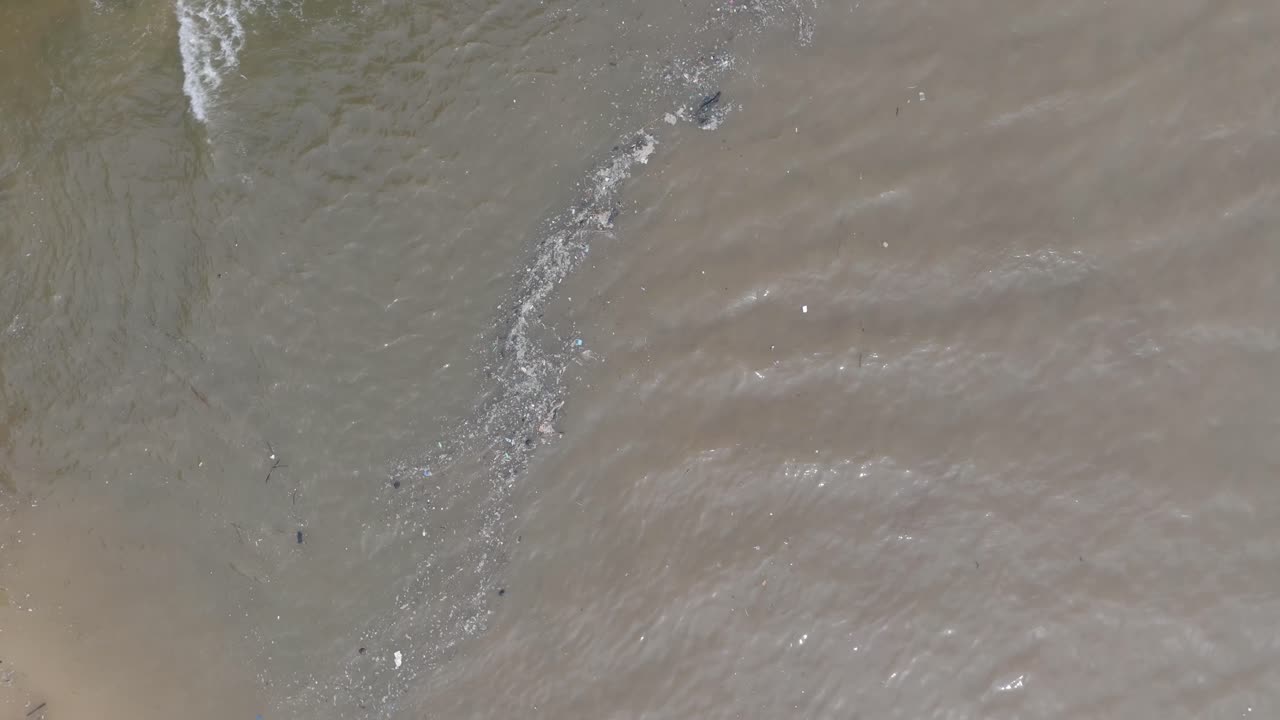 바리 인도네시아의 푸른색 열대 물과 혼합된 떠다니는 쓰레기와 진 흘러내리는 강으로 가득 찬 오염된 바다의 드론