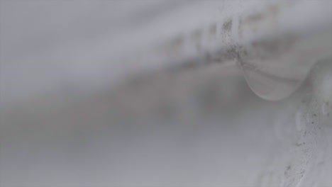 foto macro de una gota de agua cae de la pared blanca