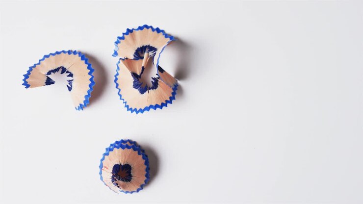 Overhead view of blue crayon shavings with copy space on white background, in slow motion