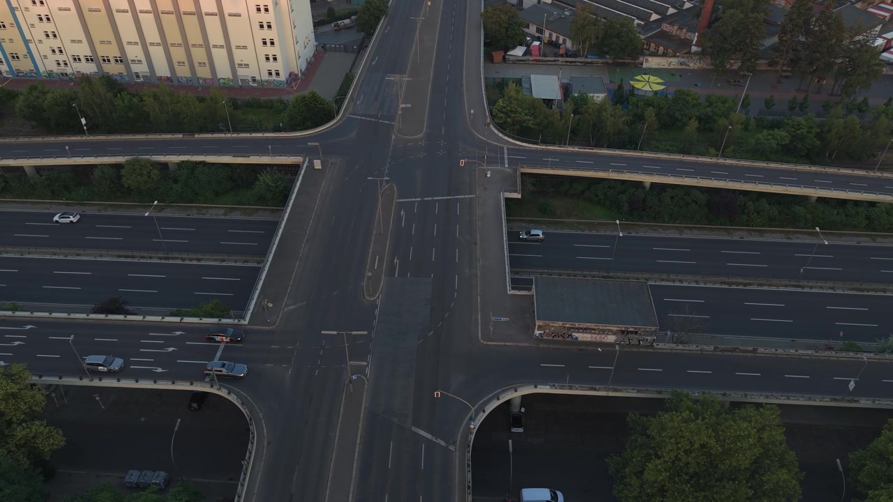 Berlin roads and bridges forming a multi level intersection, with cars moving through a cityscape. Majestic aerial view drone top down Above view