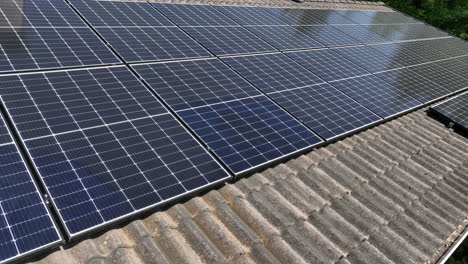 Flying-around-dirty-PV-cells-on-the-roof-a-sunlight-powered,-sustainable-house---Aerial-view