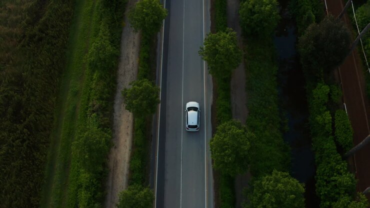 Auto che percorre una strada deserta nella campagna italiana. Vista aerea dall'alto.