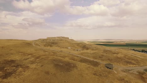 antiquities in the middle of the yellow desert with green grass in the background