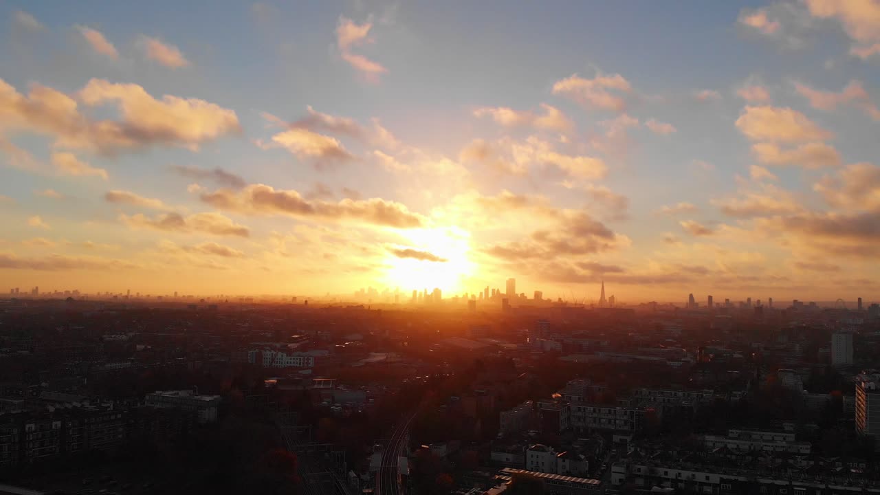 Plano de drone em recuo de um belo nascer do sol sobre a silhueta de Londres