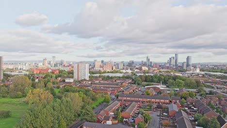 Drone-shot-flying-towards-the-centre-of-Manchester-over-some-houses-