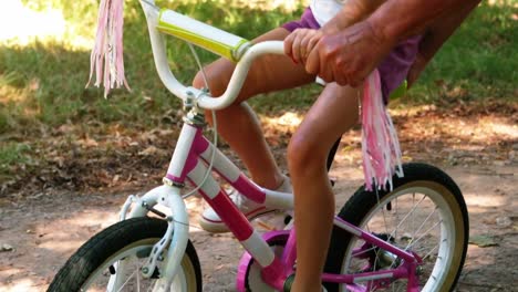 grandfather teaching his granddaughter to ride a bike