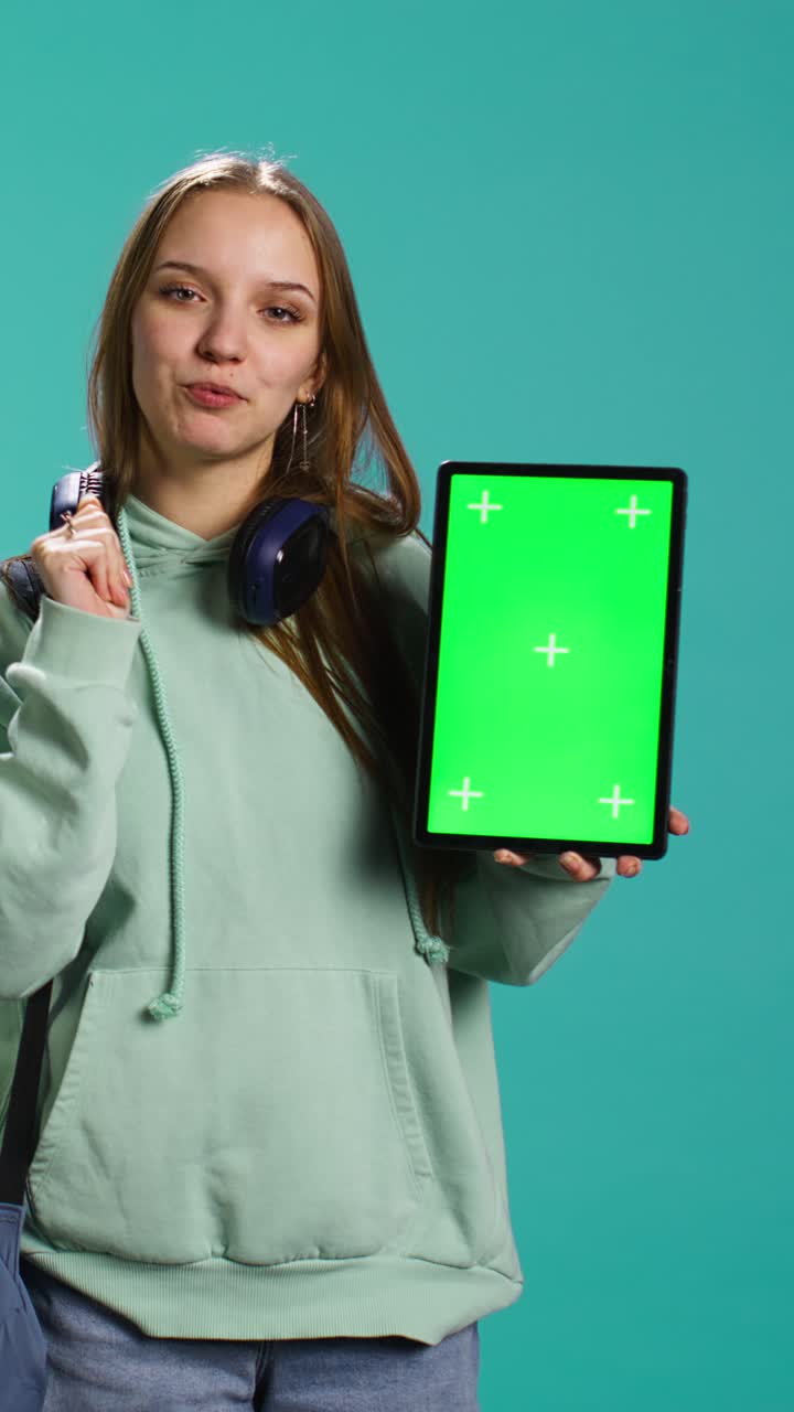 Video verticale verticale di una donna che mostra un tablet con display chroma key