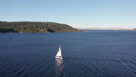 aerial flight tracks bright white sailboat sailing on deep blue lake