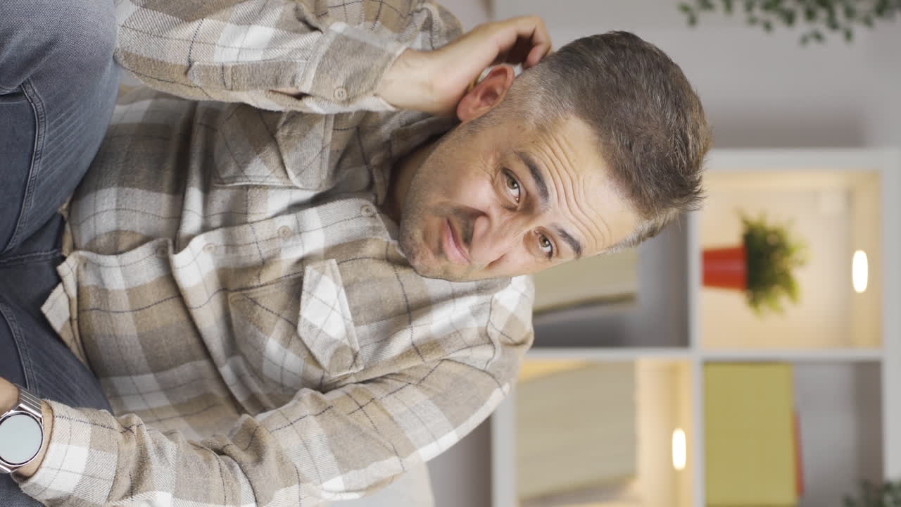 vídeo vertical de un hombre mirando pensativo a la cámara.