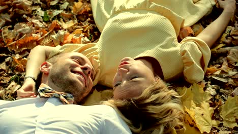 smiling couple lying in autumn park