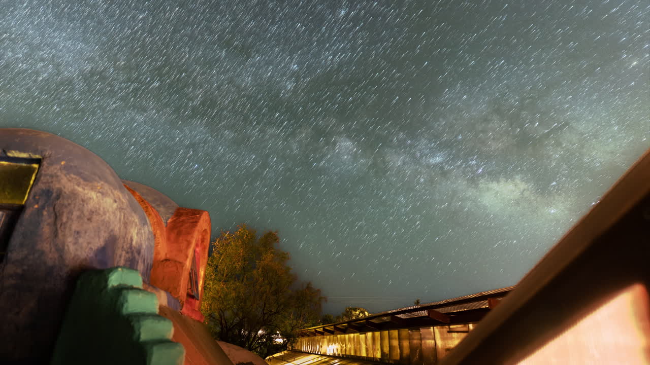 Star trail Timelapse turns stars in to comets drifting upwards over a southwestern building