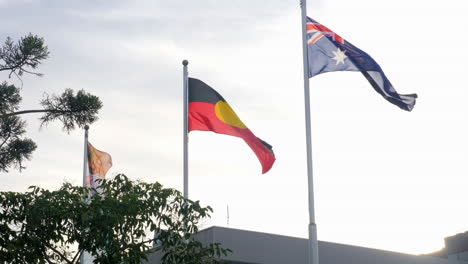 slow motion aboriginal and australian flags during sunset