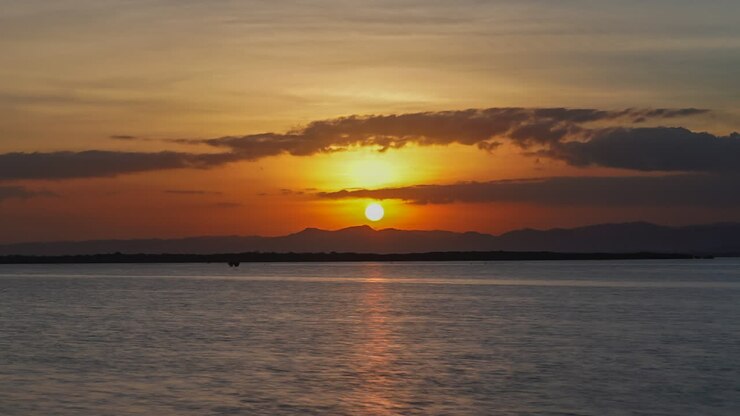 Puesta de sol dorada con reflejos en el mar en calma durante el verano en Córdova, Cebú, Filipinas