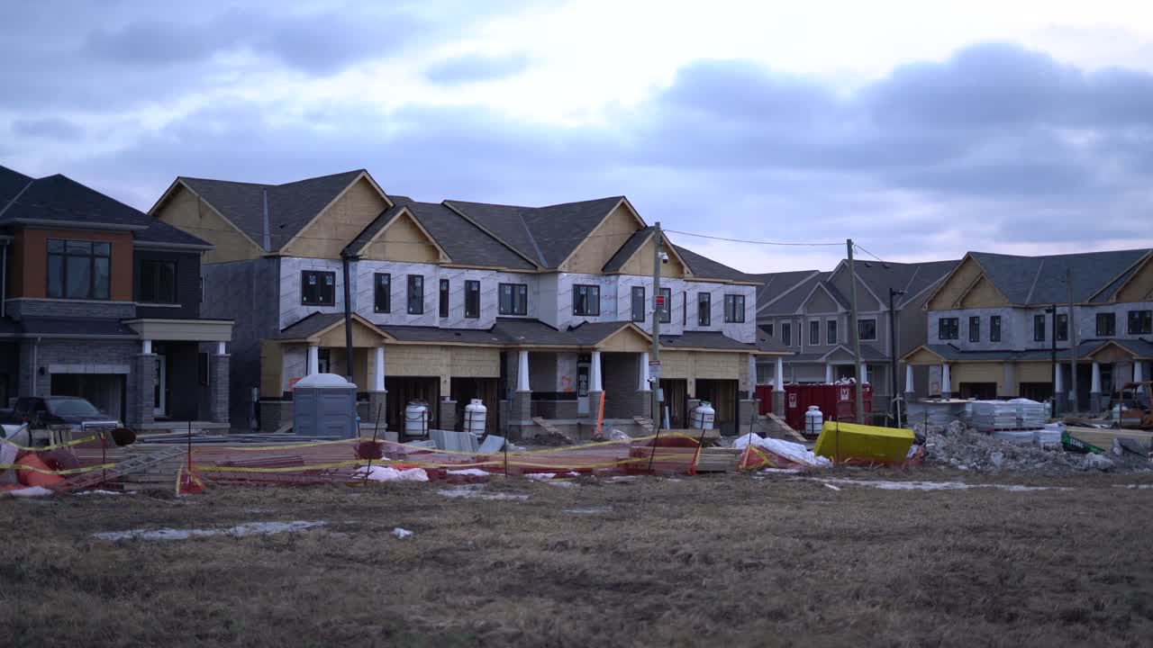 New Town houses under construction in neighbourhood development on cloudy day during winter by contractor - Building town home community by real estate developer builder - homes construction zone