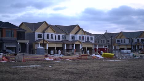 new town houses under construction in neighbourhood development on cloudy day during winter by contractor - building town home community by real estate developer builder - homes construction zone