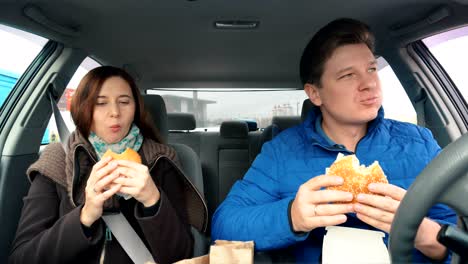 people eat hamburgers in the car