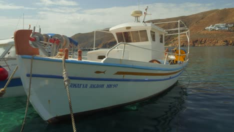 wide angle shot of typic fishing boat anchored at the port of egliali in greece, amorgos island