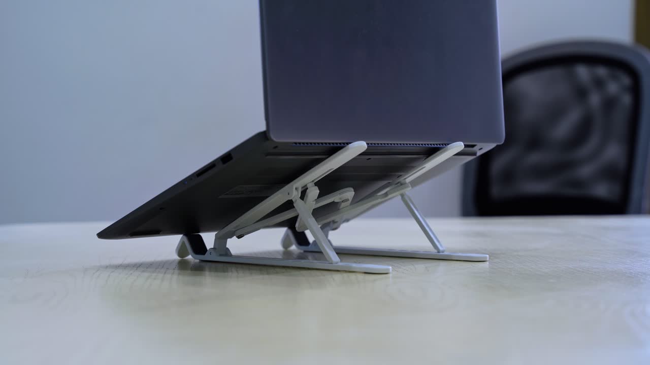 Side angle of a laptop elevated on two foldable stands—perfect for tech tutorials, ergonomic workspaces, or home office clips.
