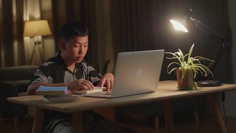 tired teenage boy feel pain eyestrain rubbing dry irritated eyes fatigued from doing home work, stressed asia teen boy suffer from headache bad vision sight problem sit at home table