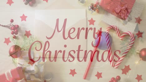 Animation-of-christmas-greetings-text-over-envelope,-christmas-presents-and-decorations