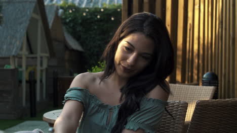 portrait of a young hispanic latina good looking woman drinking coffee or tea and smiling while sitting outdoor