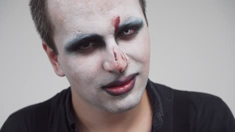 man with face paint and creepy angry smile, closeup portrait