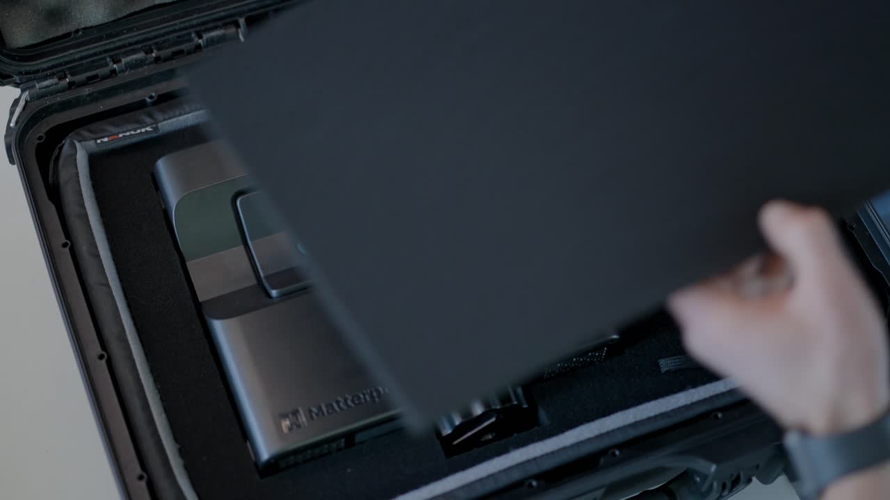 남성 평면도 기술자가 작업하기 전에 하드 케이스에서 태블릿을 제거합니다.