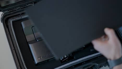 Male floor plan technician removes tablet from hard case before working