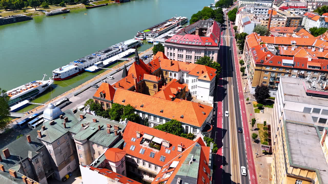 Beautiful old buildings with inner courtyards at the waterfront of the Danube. Riverboats are standing on the berths on the water. Bratislava, Slovakia. Aerial view
