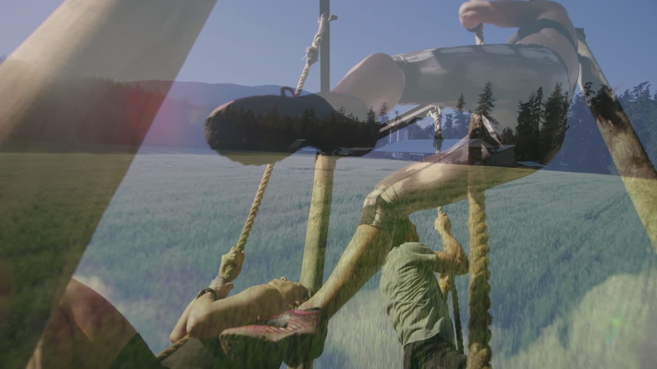 Swinging on rope, person above scenic field with mountains in background