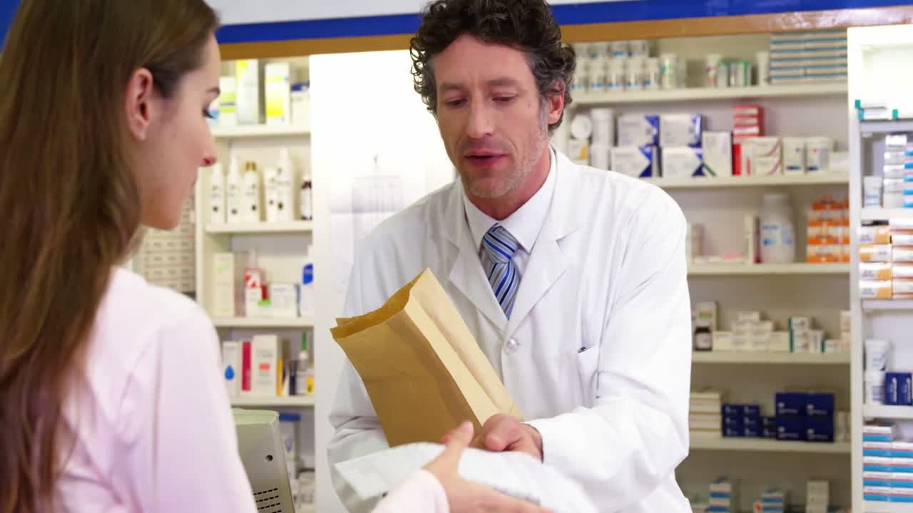 약사가 고객에게 의약품 패키지를 주는 것