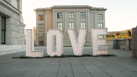 El-Estilo-De-La-Bombilla-Ilumina-El-Signo-De-Amor-Como-Decoración-De-Boda-Cerca-Del-Edificio-De-Recepción.