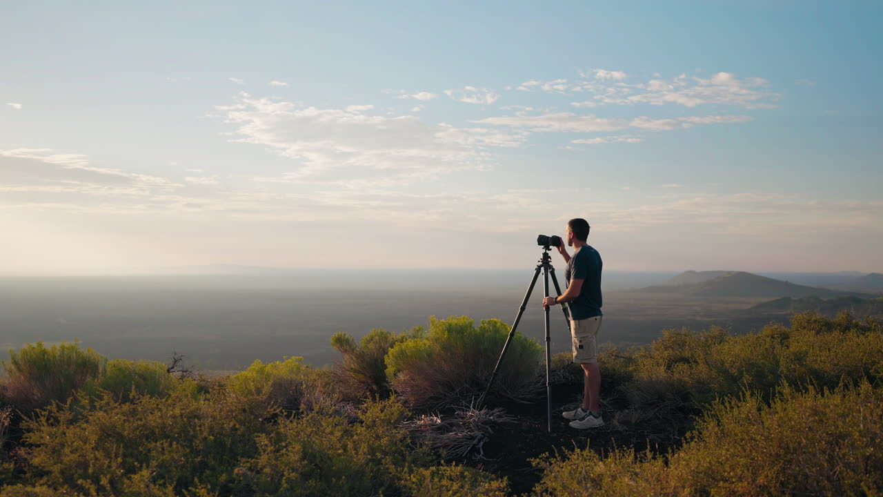 Photographer capturing a scenic landscape at sunset or sunrise