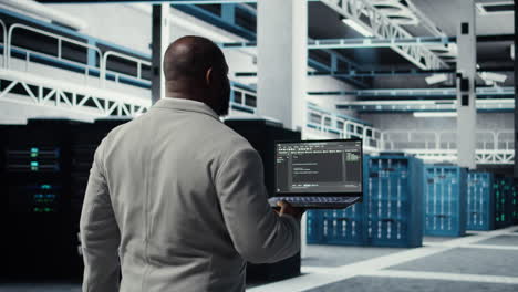vertical video data center computer scientist coding on laptop, doing software updates