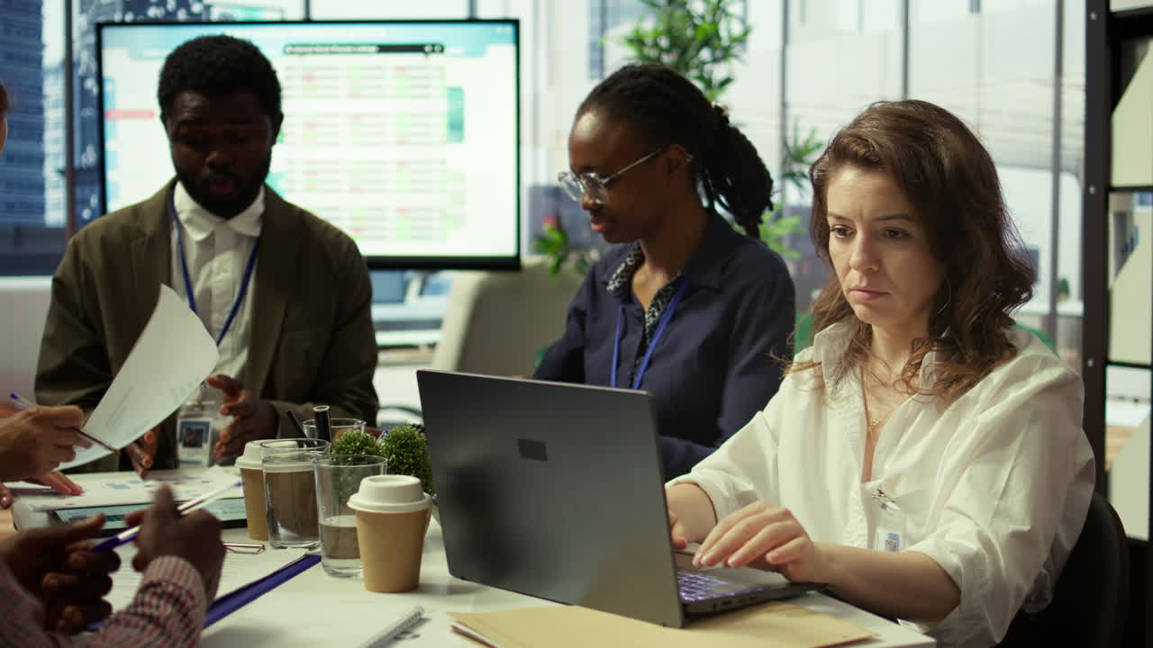 equipo de trabajadores que presentan infografías y números de ventas en un tablero interactivo