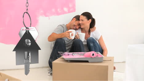 llaves de la casa y llaves colgando con una pareja sonriente en el fondo