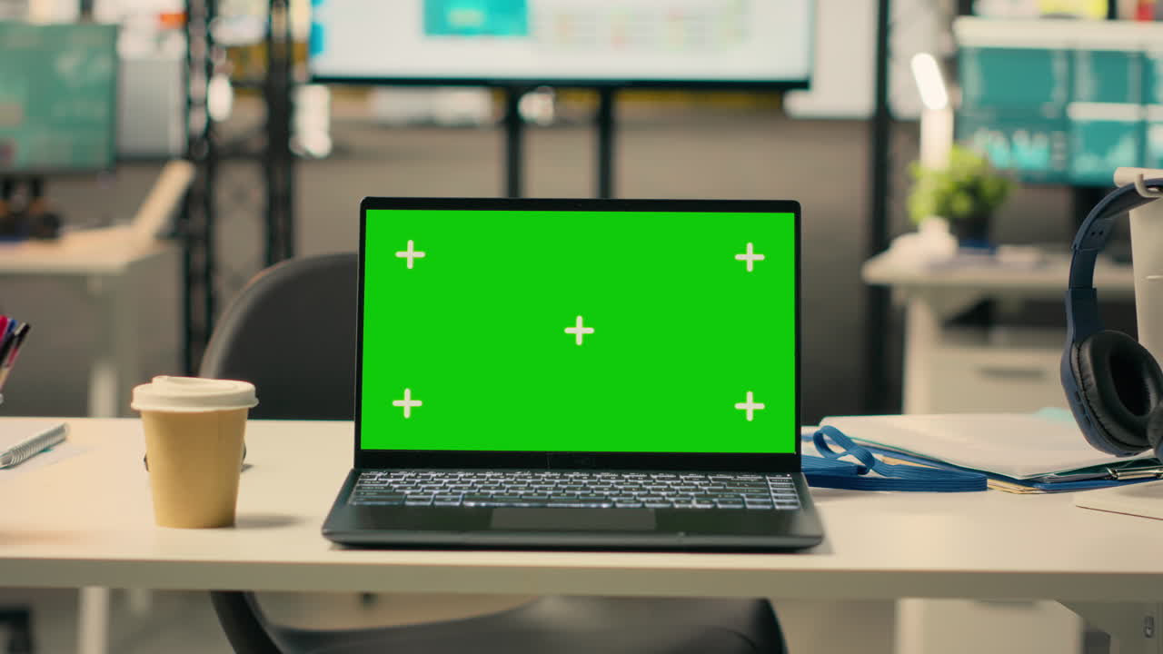 Mockup di laptop con schermo verde in una postazione di lavoro vuota in ufficio