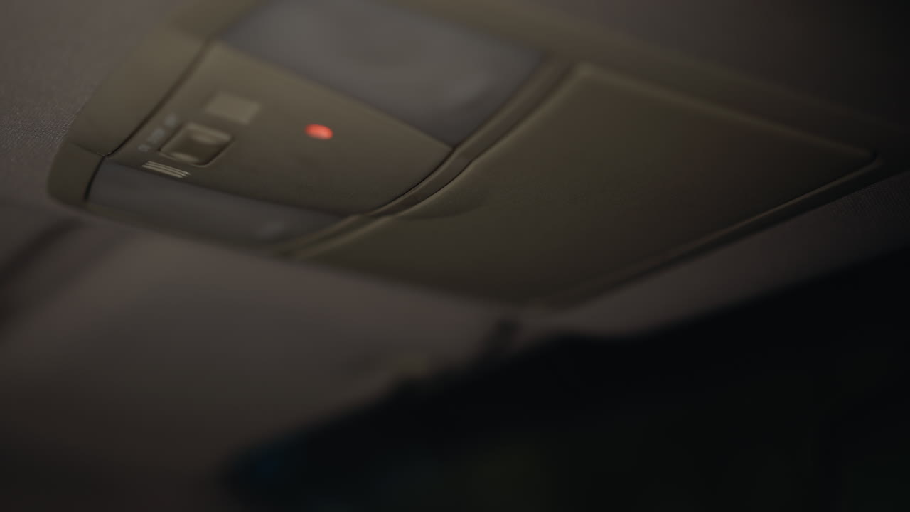 vista en primera persona de una mujer cerrando una caja del techo del coche y apagando la luz interior por la noche. mano con uñas pintadas de negro interactúa con la caja del tejado del coche y la luz apagada