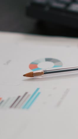 vertical video computer keyboard and business graphs and figures on paperwork files