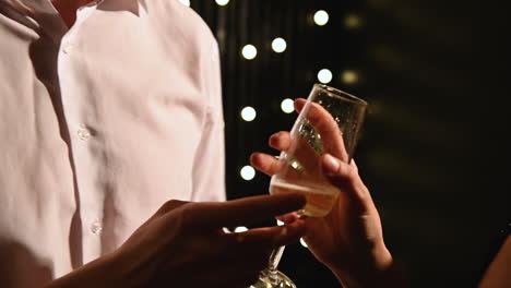 young man and woman dance and drink glass of champagne at a new year's eve party