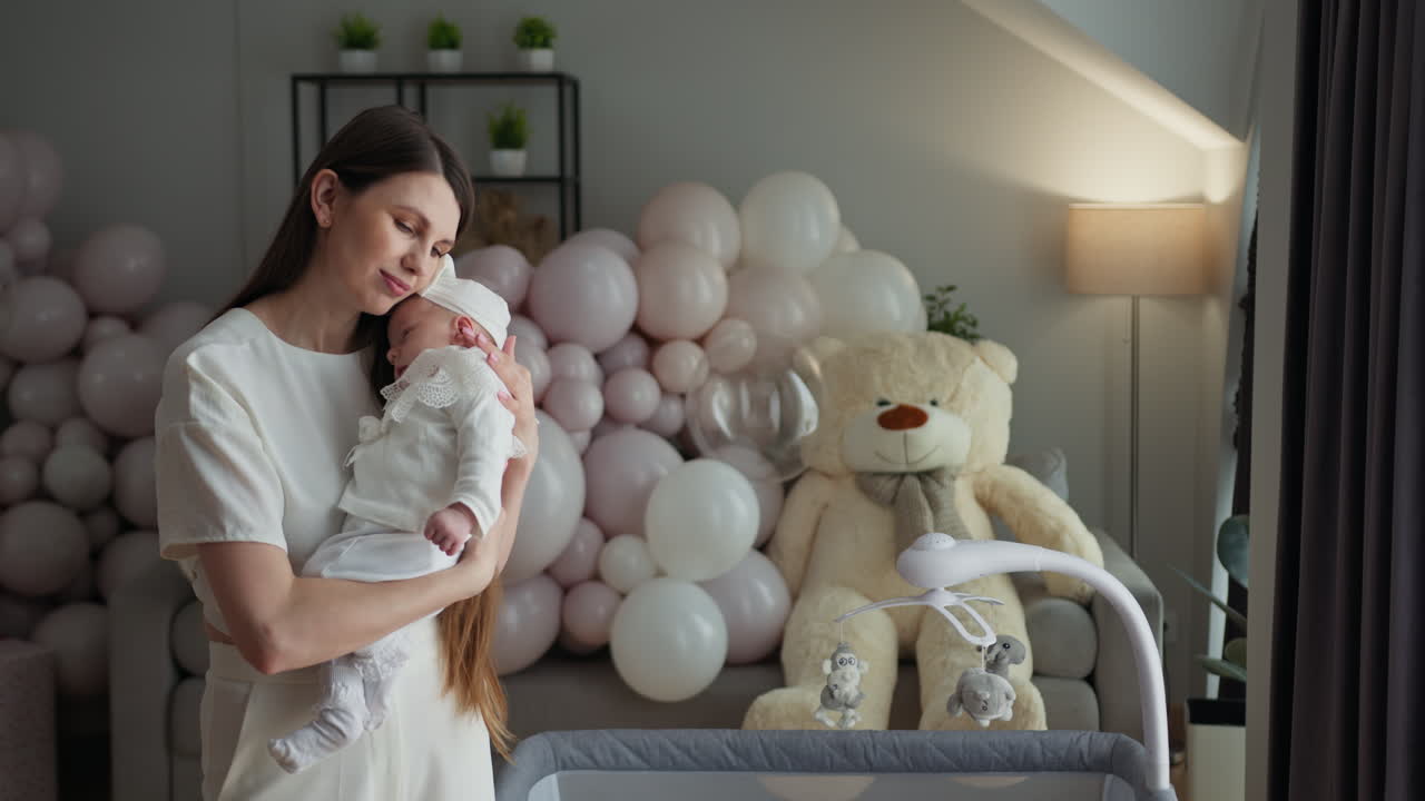 Madre abbraccia teneramente la sua neonata addormentata in una stanza decorata con palloncini e un