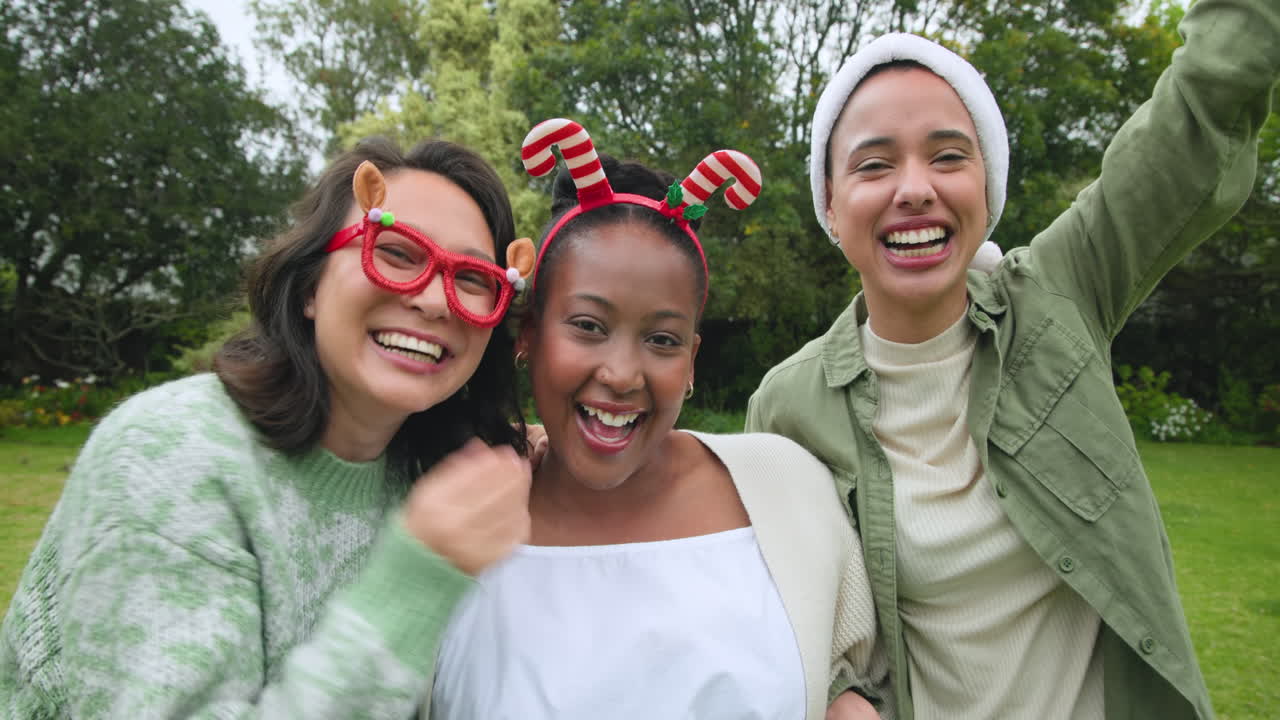 Wearing festive hats, diverse friends celebrating Christmas outdoors, smiling joyfully together