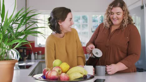 Glückliches-Kaukasisches-Lesbisches-Paar-Lächelt-Und-Gießt-Kaffee-In-Der-Küche-Ein