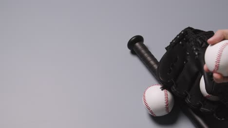 overhead baseball still life with bat and catchers mitt with person picking up ball