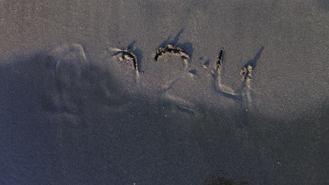 2024 written in sand on a beach with water