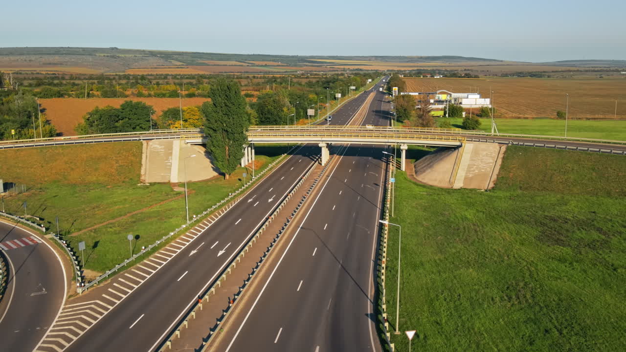 Aerial drone view of a road junction with moving cars and nature, greenery, fields, Moldova