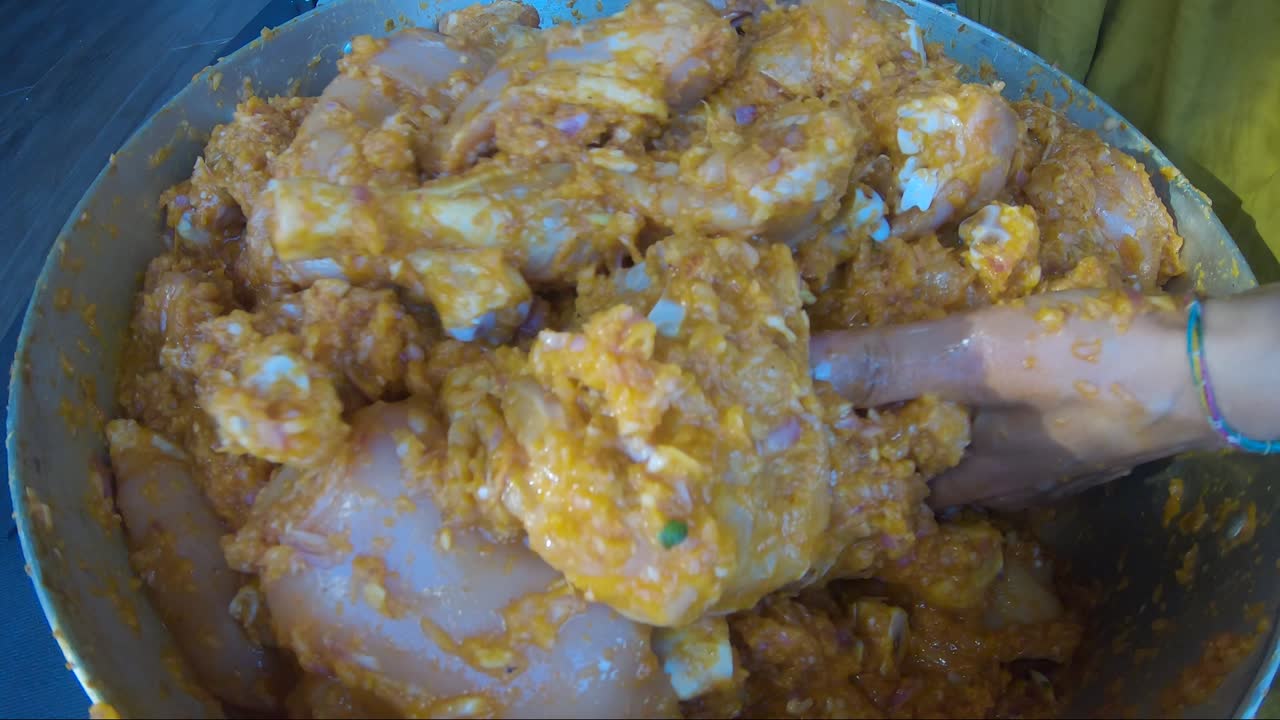 trozos de pollo crudo marinados dentro de una cacerola a mano