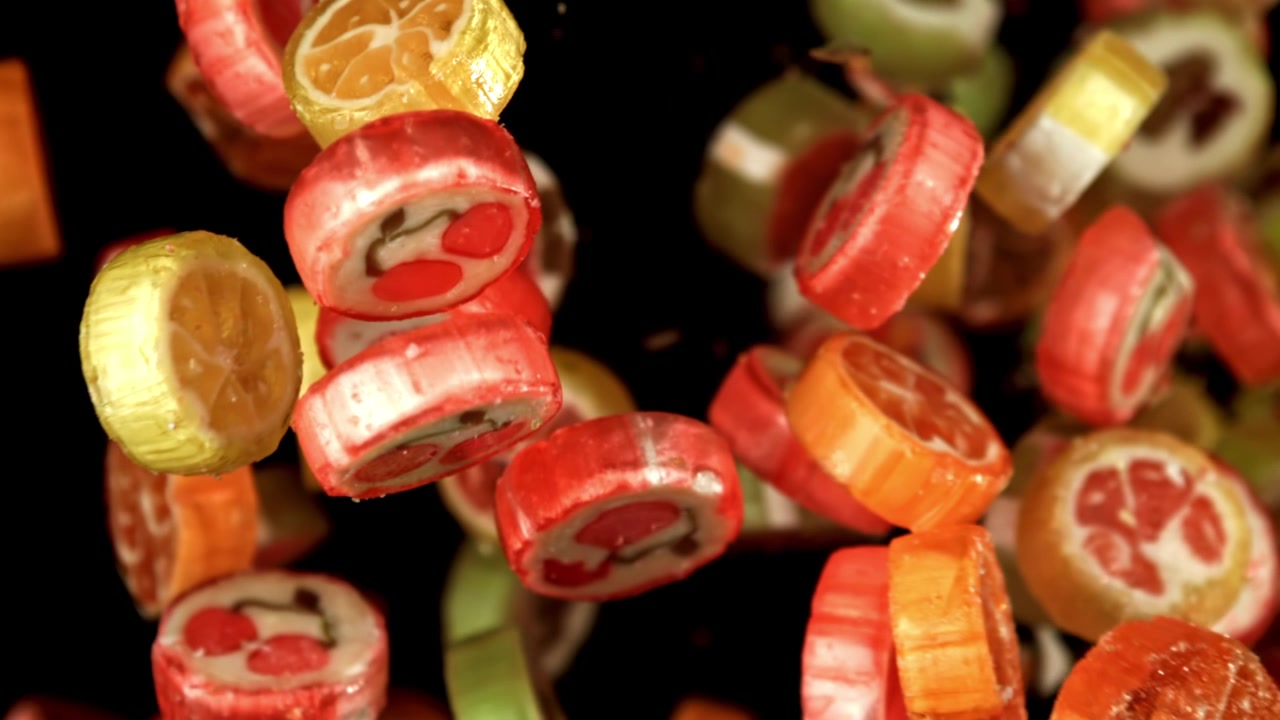 Caramelos de frutas coloridos cayendo a cámara lenta