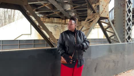 Black-woman-standing-under-bridge-waiting